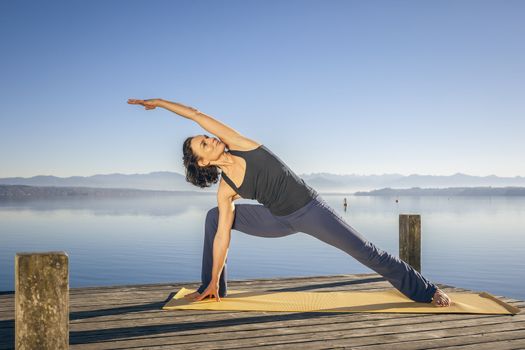 An image of a pretty woman doing yoga at the lake