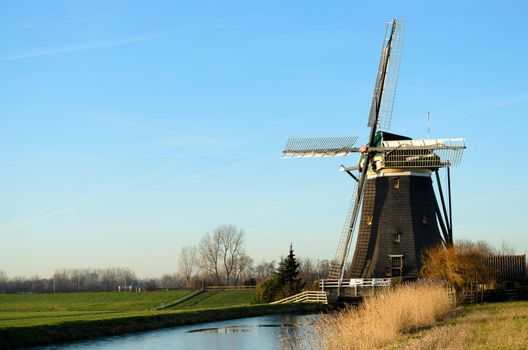 Landscape in Holland with a windmill and a canal.