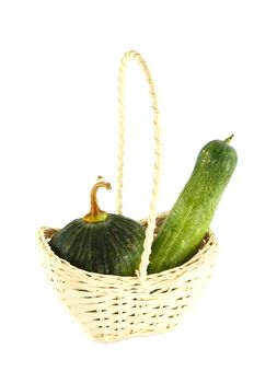 Cucumber and Pumpkin in wicker basket on white
