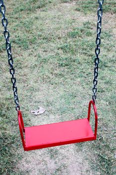 red garden swing hanging in garden