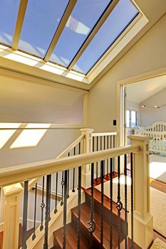 Staircase with skylight and baby room in a bright hallway.