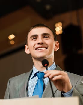 male speaker looks into the room and said into the microphone, speech at the conference