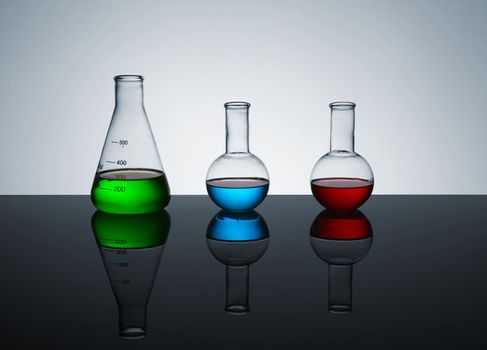 laboratory test tubes with colored liquid, place for text