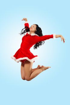 Happy smiling woman in red xmas costume jumping high