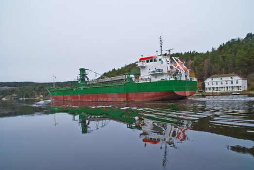 the cargo ship "sunnanhav" sailing under svinesund bridge on the way out of ringdalsfjord and to open sea, the ship has discharged its cargo in the port of halden, image is shot in november 2012 under svinesund bridge, some facts about the ship: ship type: cargo, length x breadth: 114 m X 16 m, gross tonnage: 5325, deadweight: 9402 t, flag: faroe is [fo]