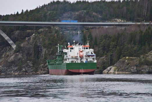 the cargo ship "sunnanhav" sailing under svinesund bridge on the way out of ringdalsfjord and to open sea, the ship has discharged its cargo in the port of halden, image is shot in november 2012 under svinesund bridge, some facts about the ship: ship type: cargo, length x breadth: 114 m X 16 m, gross tonnage: 5325, deadweight: 9402 t, flag: faroe is [fo]