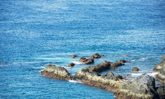 blue sea at tenerife island with lava rocks as coastline