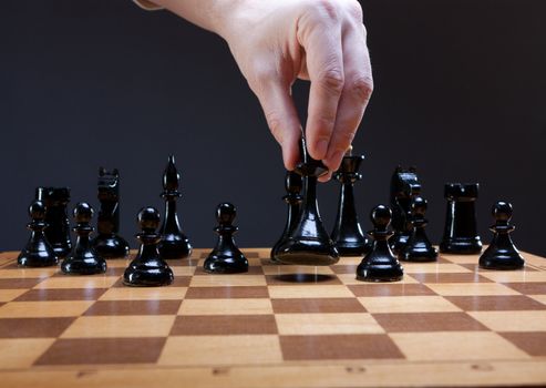 chess move with hand on dark background