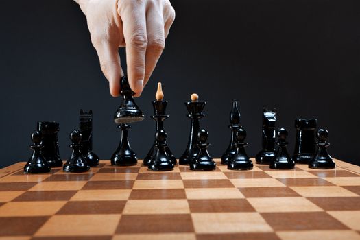 hand moves chess pawn on a dark background