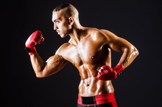 Boxer with red gloves in dark room