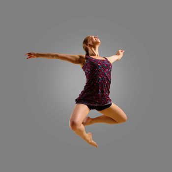 dancer jumping on a gray background, having a fun