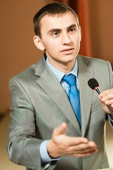 male speaker looks into the room and said into the microphone, speech at the conference