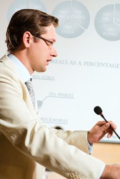 male speaker looks into the room and said into the microphone, speech at the conference