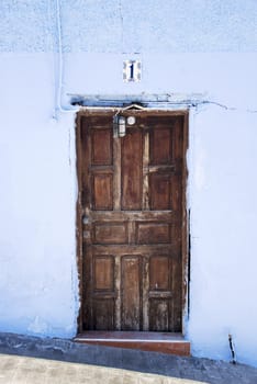 old wooden door with blue painted wall