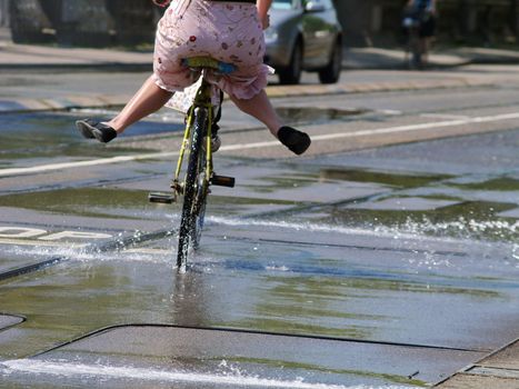 Woman bicycling into water.