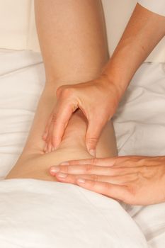 A physio gives myotherapy using trigger points on athlete woman