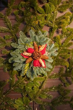 Decorative Christmas wreath of pointsetta, pine cones, evergreen