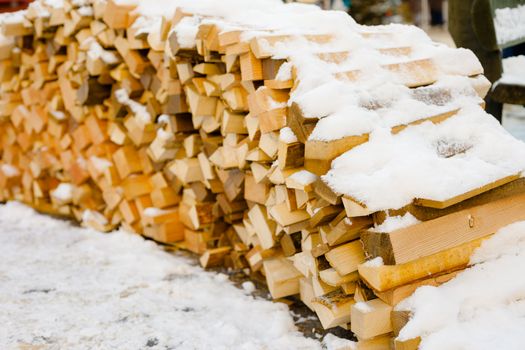 Pile of wood covered by snow after cutting