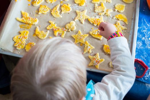 Detail of small child decorating christmas cookies