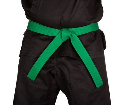 Karate green belt tied around marital artists torso wearing black dojo GI's.