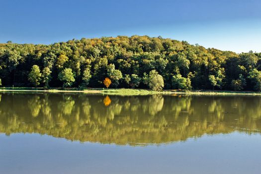 Idyllic autumn reflections on lake surface, Ravenska kapela lake, Croatia