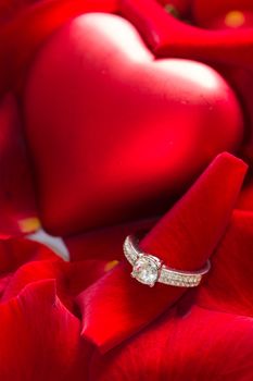 Golden diamond ring and red rose petals 