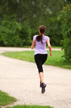 Young and attractive sporty girl running in the park