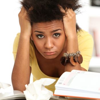 Young black woman tired from studying with books
