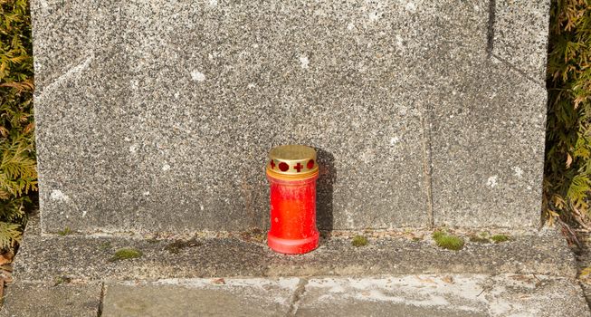 A candle for remebrance on an old grave in Holland