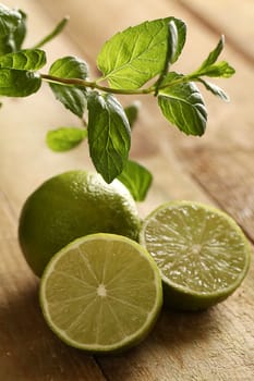 Fresh sliced lime with green mint on a wooden surface