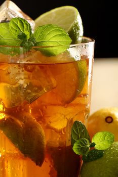 Fresh cold tea with lime, mint and lemon on a wooden surface