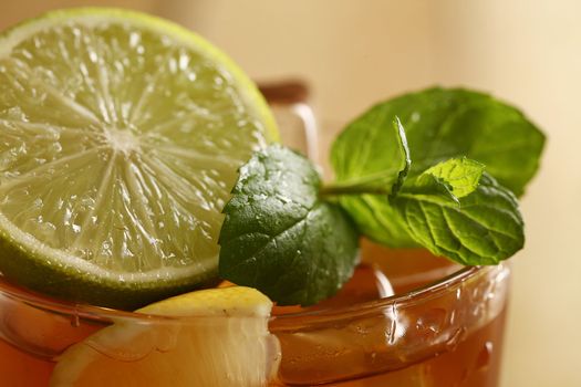 Fresh cold tea with lime, mint and lemon on a wooden surface