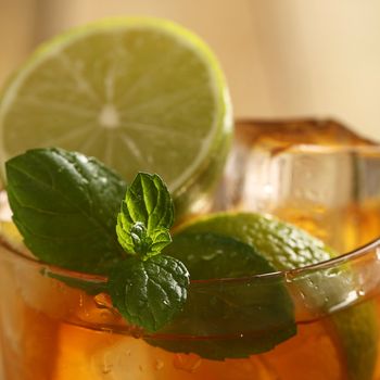 Fresh cold tea with lime, mint and lemon on a wooden surface