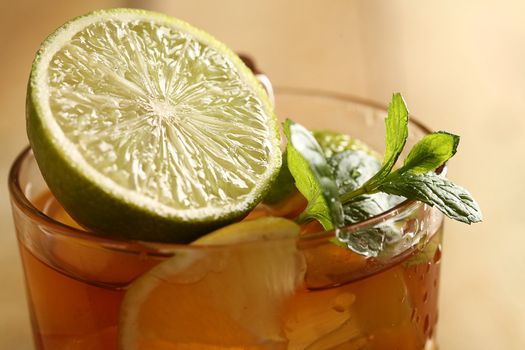 Fresh cold tea with lime, mint and lemon on a wooden surface