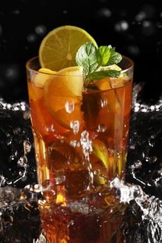 Fresh cold tea with lemon, lime and mint in water splashing