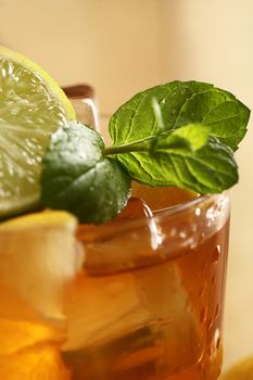 Fresh cold tea with lime, mint and lemon on a wooden surface