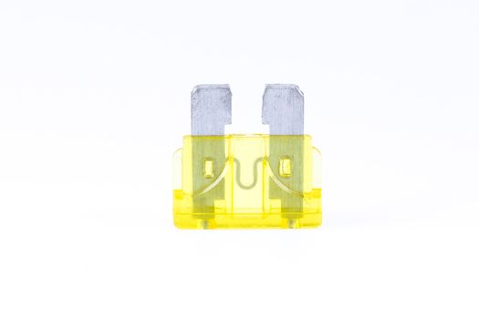 A yellow car fuse with a white background