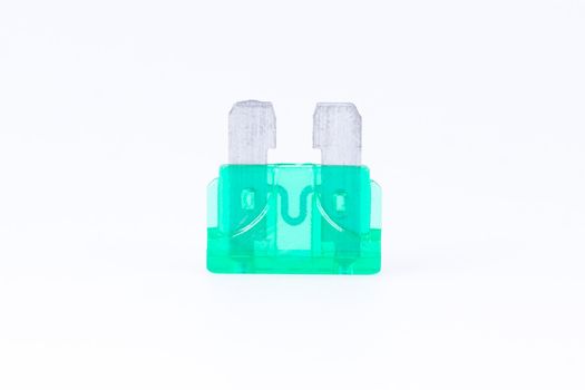 A green car fuse with a white background