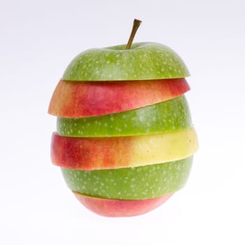 A sliced green and red apple isolated on a grey background