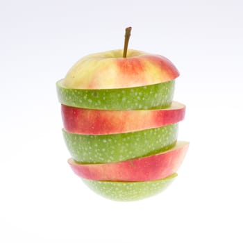 A sliced green and red apple isolated on a grey background