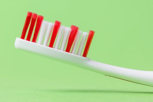 A pink toothbrush on a green background