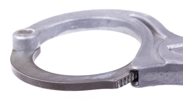 A close-up of metal handcuffs isolated on a white background