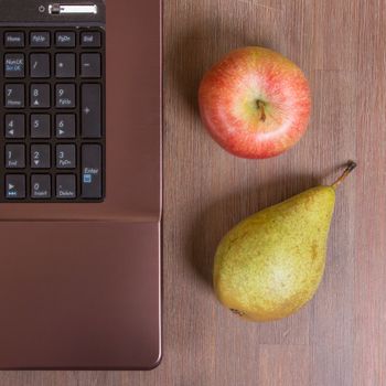 Fruit with a laptop on a wood floor