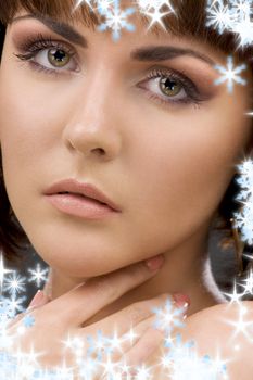 closeup portrait of lovely green-eyed woman with snowflakes