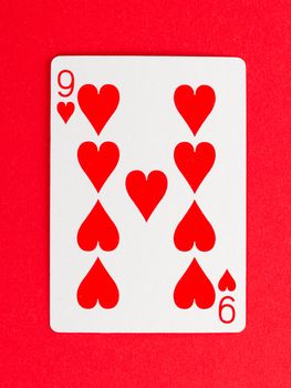 Old playing card (nine) isolated on a red background