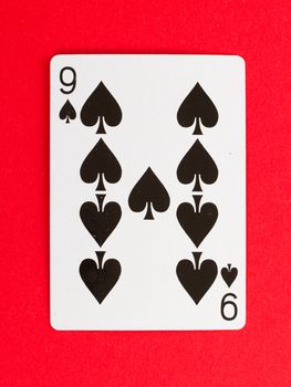 Old playing card (nine) isolated on a red background