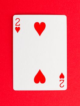Old playing card (two) isolated on a red background