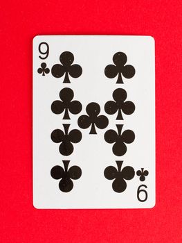 Old playing card (nine) isolated on a red background