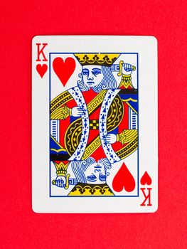 Old playing card (king) isolated on a red background