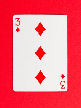 Playing card (three) isolated on a red background